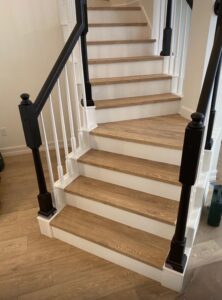 Staircase renovation with wood steps and white risers by Cornerstone Flooring in Orlando